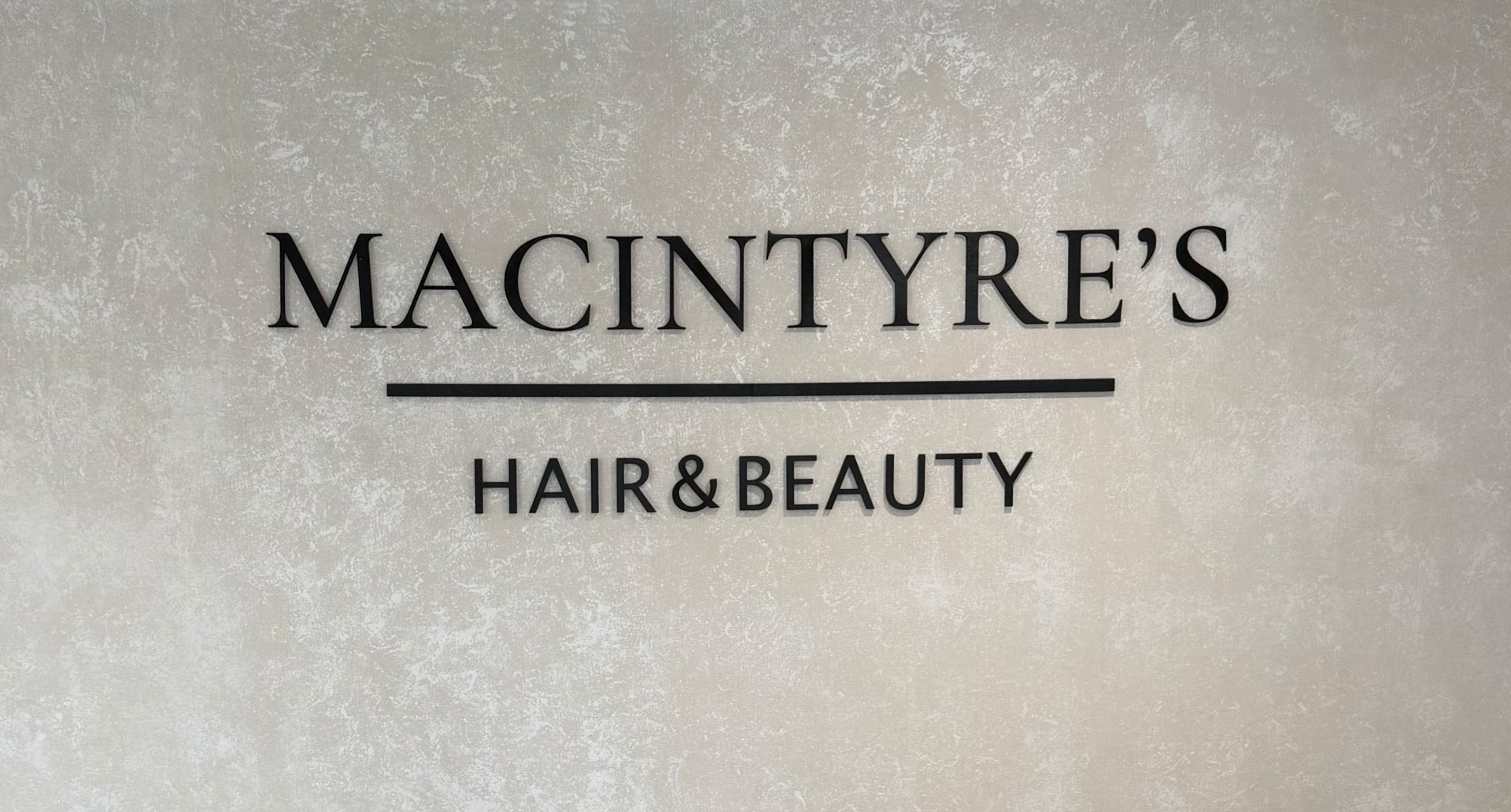 Macintyre's Hair & Beauty sign on a textured wall